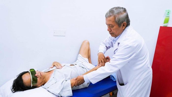  Bác sĩ Vũ đang trị liệu cho một bệnh nhân bằng phương pháp xoa bóp, bấm huyệt. Ảnh: BSCC. 