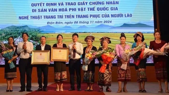 Đồng chí Nguyễn Thái Bình, Chủ tịch UBND huyện Điện Biên và đại diện lãnh đạo Sở Văn hóa - Thể thao và Du lịch Điện Biên trao Bằng công nhận Di sản văn hóa phi vật thể quốc gia Nghệ thuật trang trí trên trang phục của người Lào, cho cộng đồng dân tộc Lào ở hai huyện Điện Biên và Điện Biên Đông.