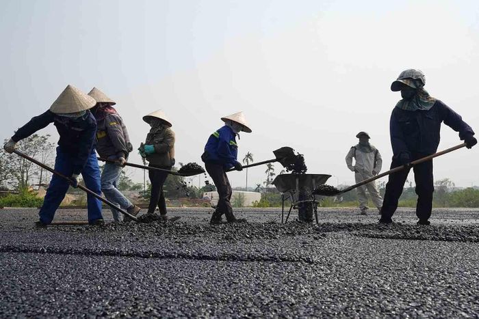 Công nhân thi công hạng mục thảm nhựa mặt đường. Nhà thầu cũng đang trong quá trình hoàn thiện trạm bê tông nhựa thứ 2, dự kiến đến tháng 12 sẽ có 2 dây chuyền bê tông nhựa hoạt động. Ảnh: Hữu Chánh