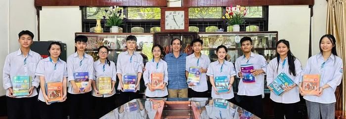 Ông Lê Bá Lương (giữa) và các cháu của Làng trẻ SOS Vinh đạt thành tích cao trong học tập nhận quà từ Nhà sách Nghệ An