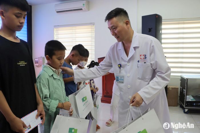 Bác sĩ Chuyên khoa II Nguyễn Văn Hướng tặng quà cho bệnh nhân nhi điều trị tại Bệnh viện Ung bướu Nghệ An. Ảnh: CSCC
