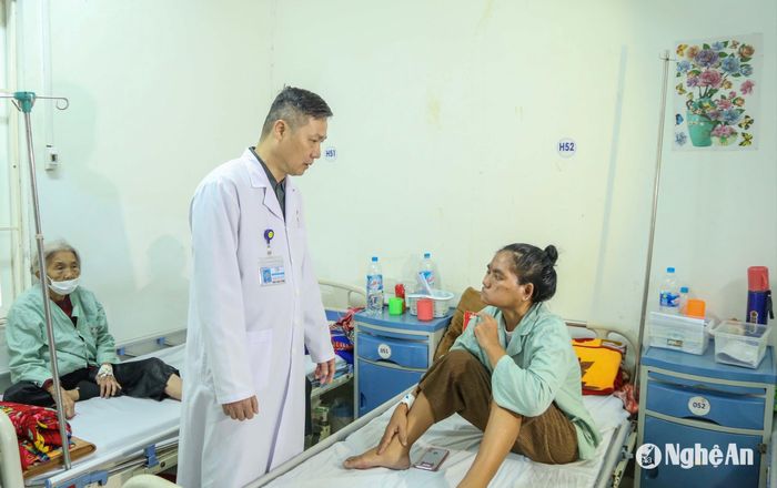 Bác sĩ Nguyễn Văn Hướng hỏi thăm tình hình điều trị của bệnh nhân. Ảnh: Đình Tuyên