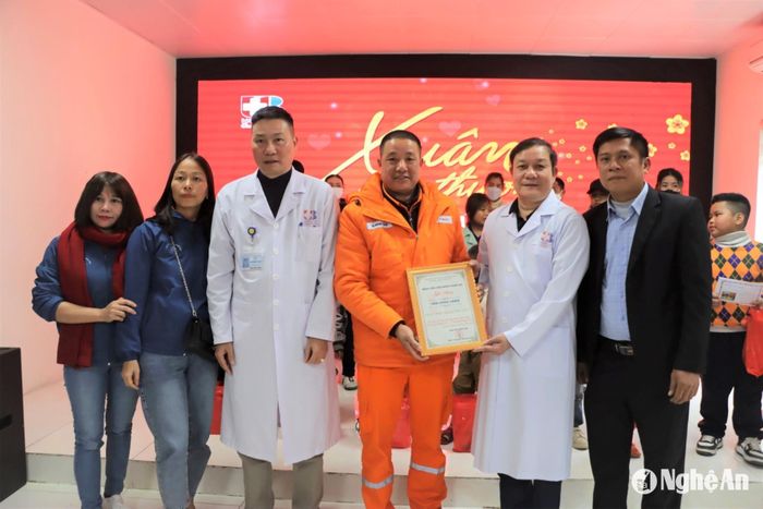 Bác sĩ Chuyên khoa II Nguyễn Văn Hướng ( áo trắng thứ 3 trái sang) cùng TS.BS Phạm Vĩnh Hùng - Phó Giám đốc Bệnh viện Ung bướu Nghệ An (áo trắng thứ hai phải sang) trao giấy chứng nhận tấm lòng vàng cho nhà hảo tâm. Ảnh: CSCC