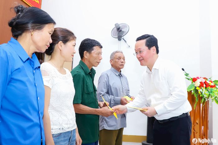 Đồng chí Nguyễn Đức Trung - Bí thư Tỉnh ủy, Chủ tịch UBND tỉnh trao tặng quà cho 10 hộ cận nghèo, hộ khó khăn của xóm 4, xã Nam Nghĩa, huyện Nam Đàn. Ảnh: Phạm Bằng