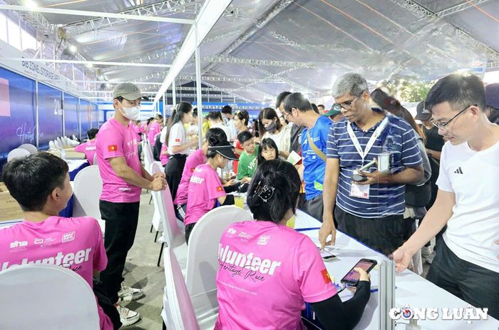  Nhân viên Ban tổ chức Giải làm thủ tục cho các vận động viên đăng ký tham gia Giải Marathon Quốc tế Di sản Hạ Long 2024. 