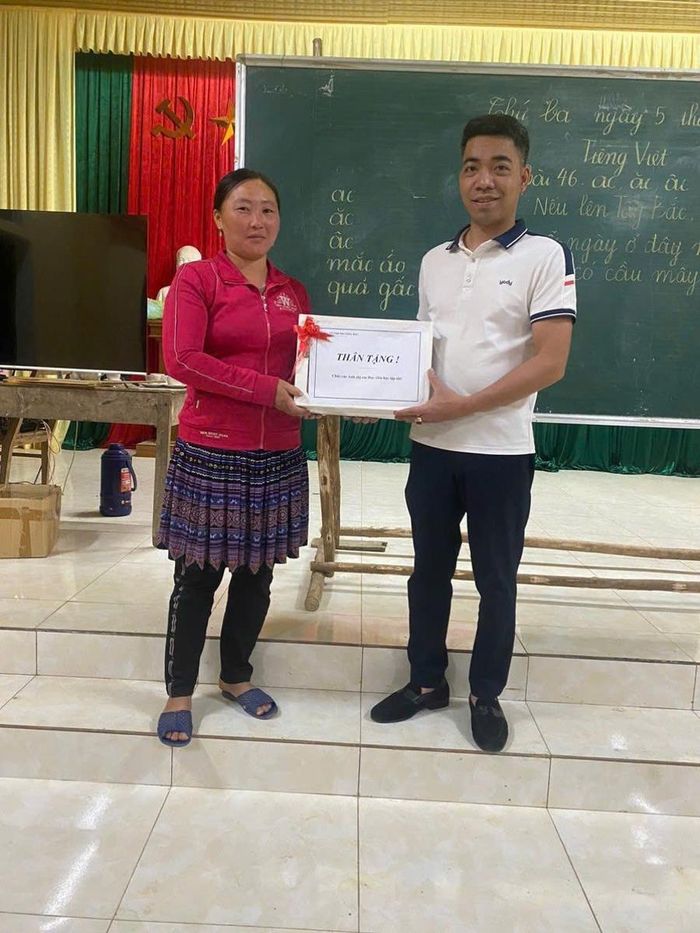  Thầy giáo Nguyễn Quang Thọ tặng quà khuyến khích học viên tại lớp học xóa mù chữ ở Khe Táu. 