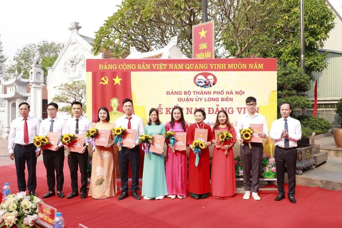 Lãnh đạo quận Long Biên trao quyết định kết nạp Đảng và tặng hoa cho các đảng viên mới. Ảnh: Đình Hiệp