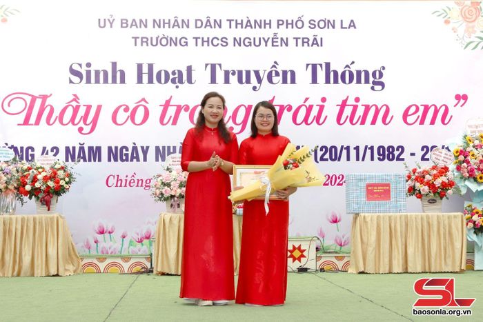 Lãnh đạo nhà trường chuyển trao giấy chứng nhận danh hiệu "Chiến sĩ thi đua cấp tỉnh" cho giáo viên nhà trường.