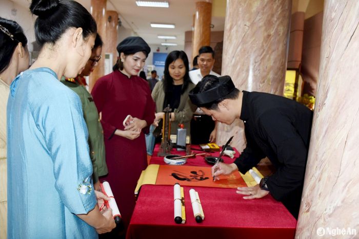 Các đại biểu tham quan hoạt động viết Thư pháp. Ảnh: Công Kiên