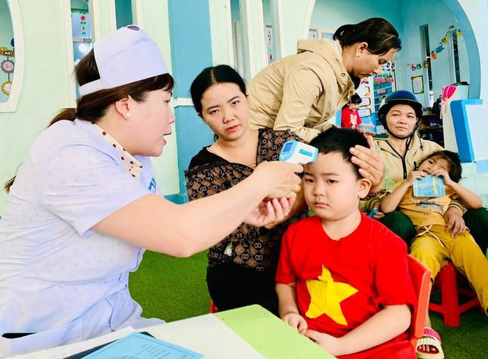 Nhân viên y tế khám sàng lọc trước khi tiêm vắc xin phòng bệnh sởi cho trẻ. Ảnh: N.N