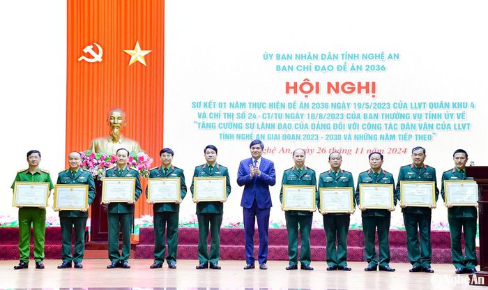 Phó Bí thư Thường trực Tỉnh ủy, Chủ tịch HĐND tỉnh Hoàng Nghĩa Hiếu trao Bằng khen của Chủ tịch UBND tỉnh tặng cho 10 tập thể có thành tích trong thực hiện Đề án 2036 của lực lượng vũ trang Quân khu 4 và Chỉ thị số 24 của Ban Thường vụ Tỉnh ủy. Ảnh: Phạm Bằng