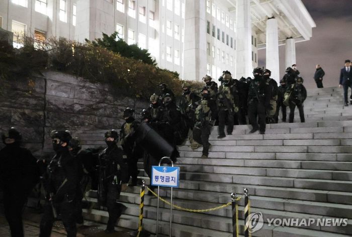 Quân đội rút khỏi tòa nhà quốc hội sau phiên bỏ phiếu. (Ảnh: Yonhap)
