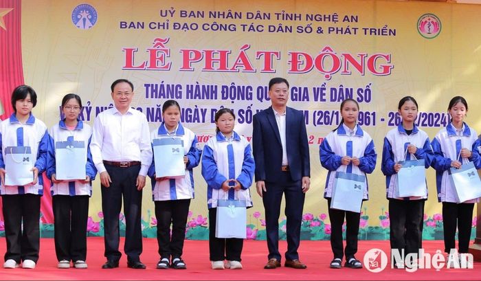 Chi Cục trưởng Chi cục Dân số - KHHGĐ Hoàng Đình Tùng và Phó Chủ tịch UBND huyện Thanh Chương - Nguyễn Hữu Hiền trao quà cho học sinh Trường THPT Thanh Chương 3. Ảnh: Mỹ Hà