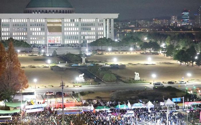 Người dân tụ tập bên ngoài Tòa nhà Quốc hội ở Seoul. Ảnh: YONHAP / AFP 