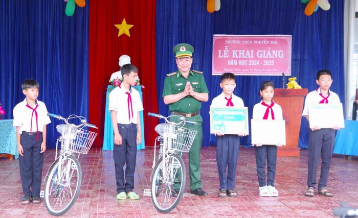 Đại tá Phạm Anh Chương, Chỉ huy trưởng BĐBP Cà Mau tặng học bổng và xe đạp cho các em học sinh trong Chương trình “Nâng bước em tới trường - Con nuôi đồn biên phòng” tại xã Khánh Tiến, huyện U Minh, tỉnh Cà Mau. Ảnh: Hoàng Tá