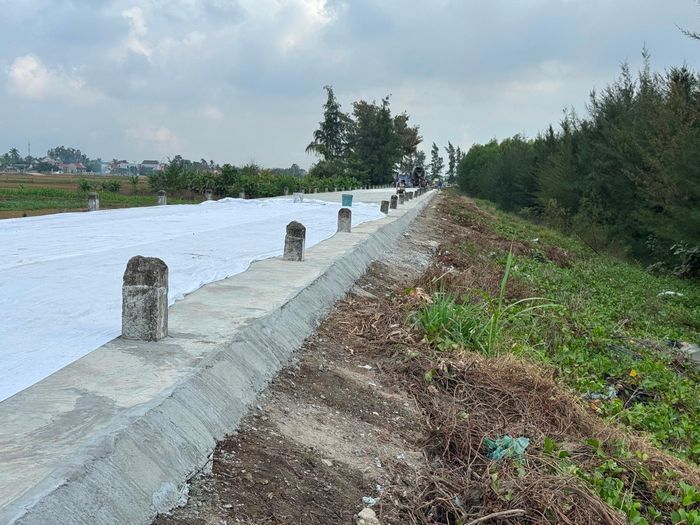 Trên nền đê biển cũ được làm lạch, các nhà thầu tôn dày thêm khoảng 20 cm bê tông và láng mịn và dự kiến sẽ sơn vẽ phản quang lại hệ thống cọc tiêu chạy dọc 2 bên đê. Ảnh: Nguyễn Hải