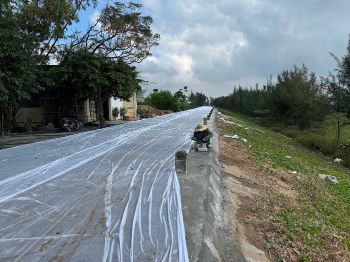 Thợ thi công đang hoàn thiện hạng mục chân các cọc biển báo với mặt đê mới được thảm lại bằng bê tông. Ảnh: Nguyễn Hải