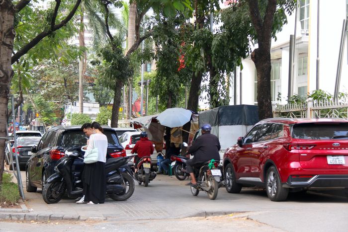  Nhiều khu vực vừa trở thành bãi để ô tô, xe máy, vừa là địa điểm kinh doanh. Để đi qua khu vực, người dân phải "luồn lách" đi bộ qua các phương tiện dừng đỗ hoặc chọn đi xuống lòng đường. 