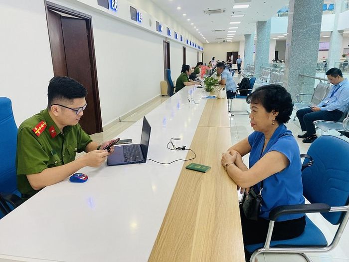 Cán bộ Công an tỉnh giúp người dân cài đặt VNeID tại Trung tâm Phục vụ HCC tỉnh Quảng Ninh. (Ảnh: QMG)