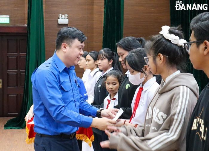 Bí thư Thành đoàn Lê Công Hùng (bên trái), trao học bổng của Quỹ Thiện Tâm cho học sinh vượt khó học giỏi năm 2024. Ảnh: N.Q