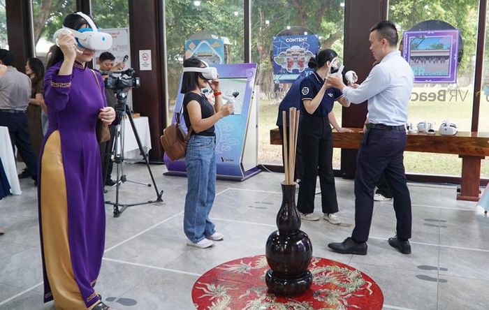 Du khách hào hứng trải nghiệm kính thực tế ảo khi tham quan Khu di sản Hoàng cung Huế. Ảnh: TTBTCĐH