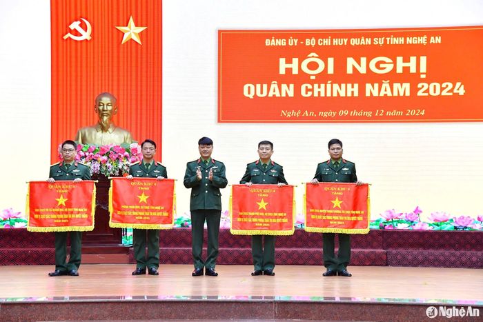Đại tá Hoàng Duy Chiến – Phó Tham mưu trưởng Quân khu 4 trao cờ thi đua xuất sắc của Quân khu 4 cho 4 tập thể thuộc Bộ Chỉ huy Quân sự tỉnh Nghệ An. Ảnh: Thành Chung