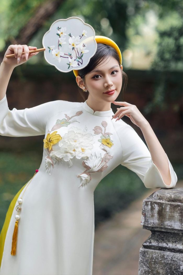 Sắc trắng ngà nhẹ nhàng, thanh lịch, kết hợp cùng họa tiết chìm tinh tế, chiếc áo dài như gói trọn sự bình yên và thanh thoát của những ngày đầu xuân. Màu sắc nhã nhặn này không chỉ tôn lên nét dịu dàng của người mặc mà còn mang lại cảm giác trang nhã, phù hợp với mọi không gian Tết.