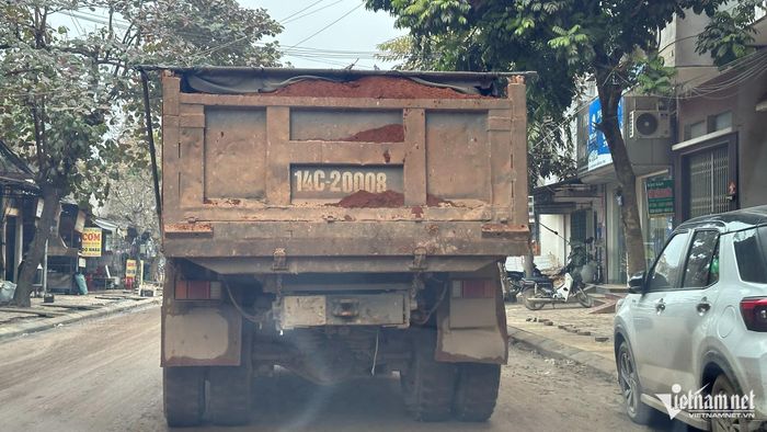 Xe vận chuyển đất che đậy sơ sài, đất đá rơi vãi ra đường. Ảnh: Đức Hoàng
