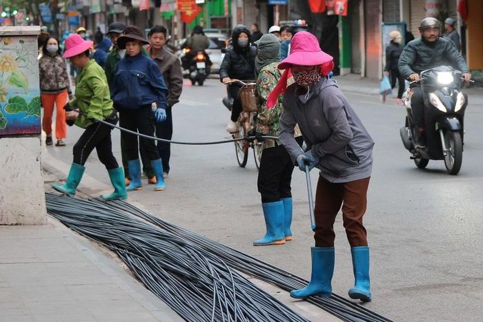 Giá rét khiến công việc của người lao động thêm vất vả. (Ảnh: Hoàng Hiếu/TTXVN)