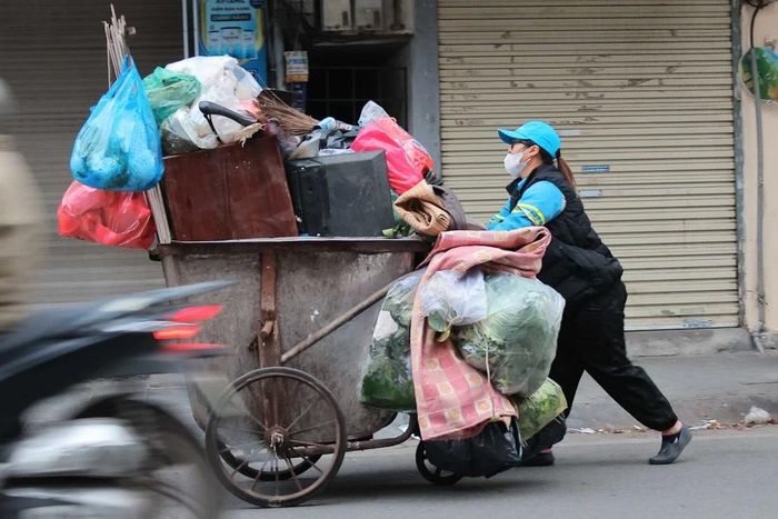 Công nhân môi trường vẫn cần mẫn làm đẹp cho thành phố dù trời rét buốt. (Ảnh: Hoàng Hiếu/TTXVN)