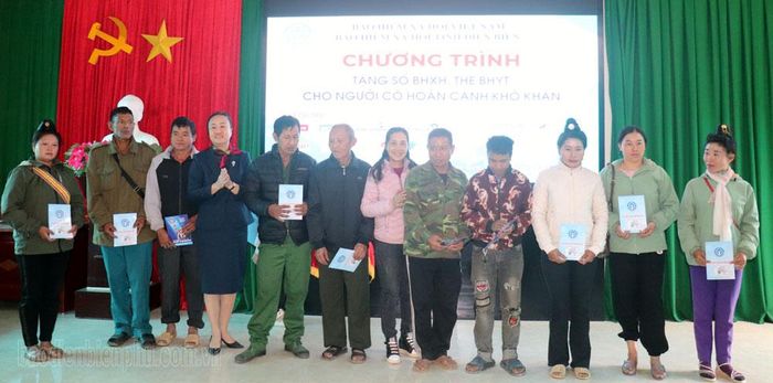 Đại diện lãnh đạo UBND xã Thanh Minh và nhà tài trợ trao tặng thẻ BHYT cho người dân xã Thanh Minh.