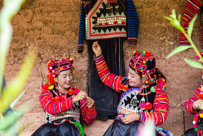 Phụ nữ Hà Nhì thêu hoa văn mũ áo.