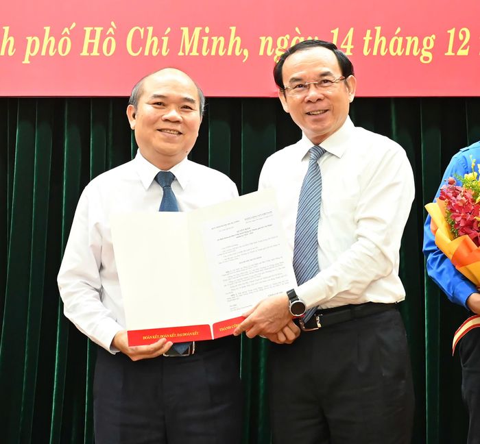 Bí thư Thành ủy TPHCM trao quyết định của Ban Bí thư Trung ương Đảng đến đồng chí Trần Văn Bảy. Ảnh: VIỆT DŨNG