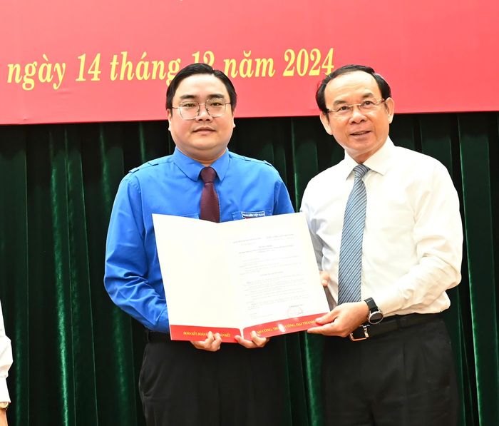 Bí thư Thành ủy TPHCM trao quyết định của Ban Bí thư Trung ương Đảng đến đồng chí Ngô Minh Hải. Ảnh: VIỆT DŨNG
