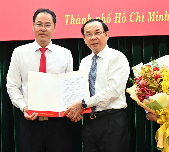 Bí thư Thành ủy TPHCM trao quyết định của Ban Bí thư Trung ương Đảng đến đồng chí Nguyễn Thành Trung. Ảnh: VIỆT DŨNG