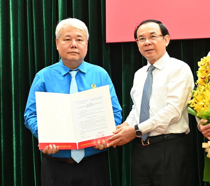 Bí thư Thành ủy TPHCM trao quyết định của Ban Bí thư Trung ương Đảng đến đồng chí Võ Khắc Thái. Ảnh: VIỆT DŨNG