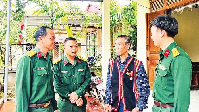 Cán bộ, chiến sĩ Ðoàn Kinh tế-Quốc phòng 207 thăm hỏi người có uy tín vùng biên giới huyện Nam Giang, tỉnh Quảng Nam.