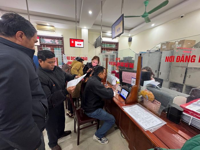 Người dân trao đổi về mẫu đơn đề nghị cấp đổi và chuyển mục đích sử dụng đất tại Bộ phận một cửa huyện Nghi Lộc. Ảnh: Nguyễn Hải
