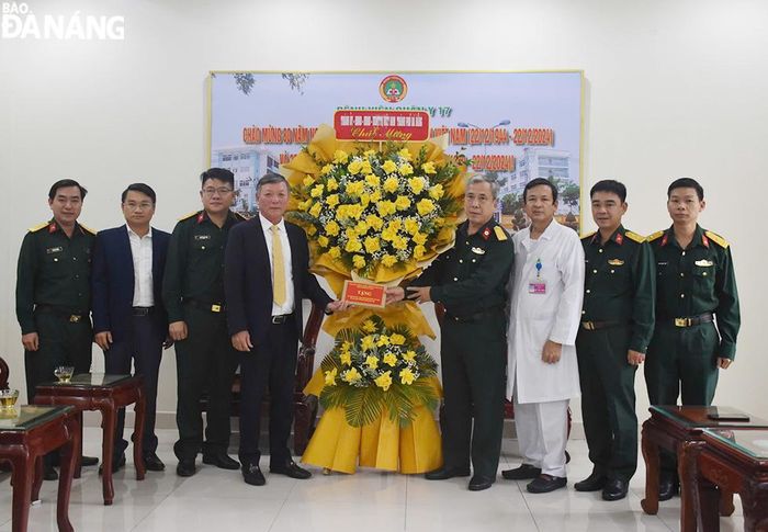 Chủ tịch Ủy ban MTTQ Việt Nam thành phố Lê Văn Trung (thứ 4, bên trái sang) chúc mừng Bệnh viện Quân y 17. Ảnh: THU HÀ