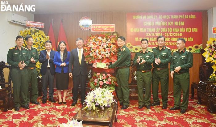 Chủ tịch Ủy ban MTTQ Việt Nam thành phố Lê Văn Trung (thứ 5, bên trái sang) chúc mừng Bộ Chỉ huy Quân sự thành phố. Ảnh: THU HÀ