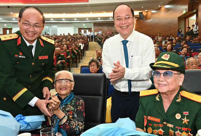  Phó Bí thư Thường trực Thành ủy TPHCM Nguyễn Hồ Hải và Trung tướng Nguyễn Văn Nam, Tư lệnh Bộ Tư lệnh TPHCM tặng hoa, gửi lời tri ân đến các Mẹ Việt Nam Anh hùng. Ảnh: VIỆT DŨNG 