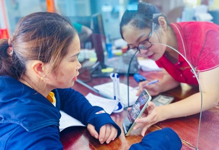 Các ngân hàng đều bố trí nhân viên trực tiếp hướng dẫn khách hàng cập nhật thông tin, cài đặt sinh trắc học. Ảnh: T.P