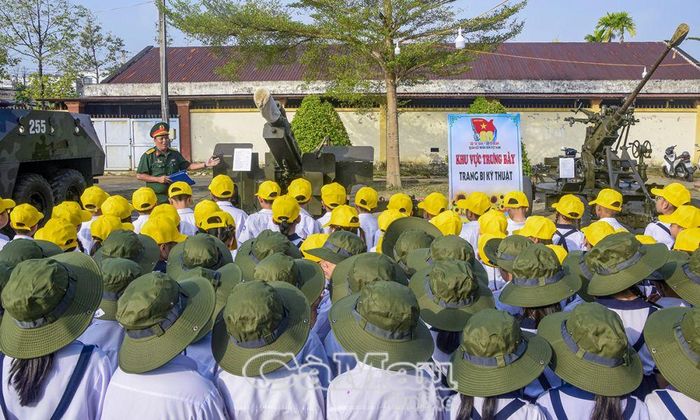 Cán bộ thuyết trình cho các em thiếu nhi hiểu về các trang thiết bị được trưng bày.