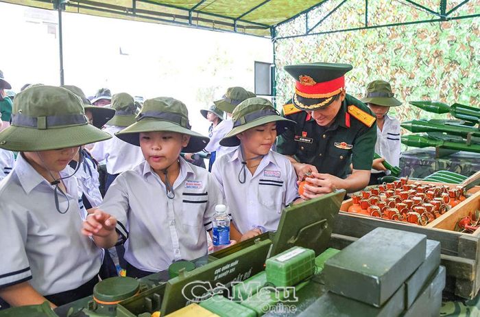 Các em thiếu nhi thích thú tìm hiểu mô hình học cụ của các chú bộ đội.