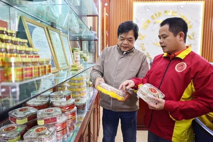 Anh Đinh Văn Thuận (người bên phải) giới thiệu sản phẩm từ tổ yến với khách hàng. (Ảnh: Trường Huy)