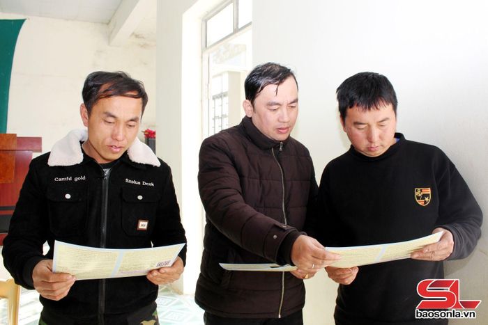 Cán bộ Trung tâm TGPL Nhà nước phát tờ gấp, hướng dẫn người dân bản Kéo Bó, xã Nà Bó, tìm hiểu, nghiên cứu. 