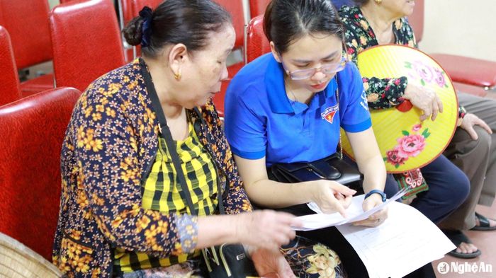 Cán bộ BHXH Nghệ An hướng dẫn người hưởng lương hưu, trợ cấp Bảo hiểm xã hội hàng tháng chuyển đổi sang hình thức nhận chế độ qua tài khoản cá nhân. Ảnh: CSCC
