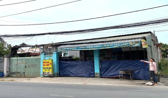 Nguyên đơn Mai Hoàng Oanh đứng trước phần đất tranh chấp