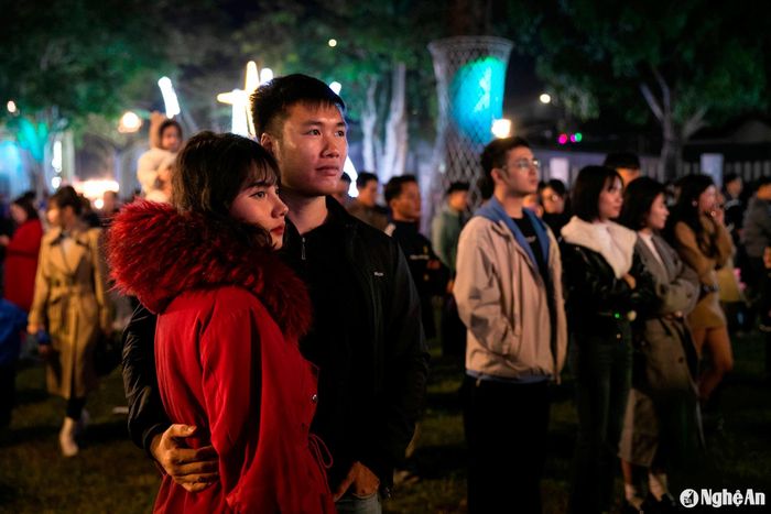 Đôi bạn trẻ tay trong tay thưởng thức các bài thánh ca trong đêm Giáng sinh. Ảnh: Đức Anh