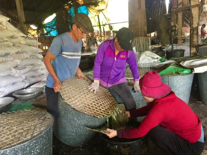 Ông Đồng Văn Chính (bìa phải) là một trong số ít người ở Ba La - Vạn Tượng giữ nghề làm đường phèn truyền thống của gia đình.